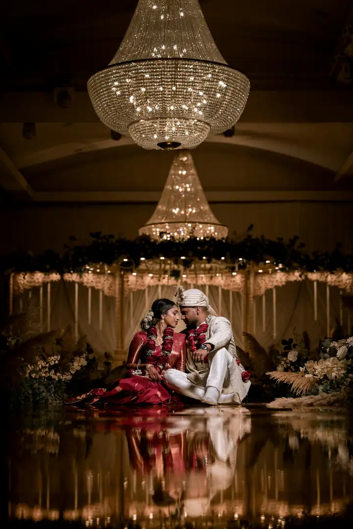 Newlyweds at their reception under chandeliers